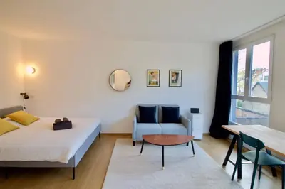 a bedroom with a bed and a couch and a table at New Studio ! in Brussels