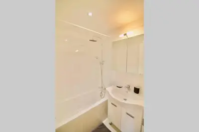 a white bathroom with a sink and a tub at New Studio ! in Brussels