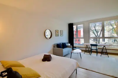 a bedroom with a bed and a living room at New Studio ! in Brussels