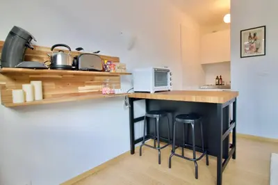 a kitchen with a counter with stools and a microwave at New Studio ! in Brussels