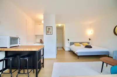 a bedroom with a bed and a kitchen with a counter at New Studio ! in Brussels