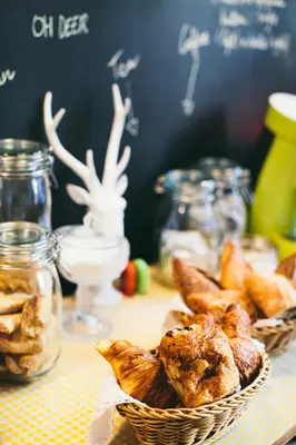 a table with two baskets of pastries and glass jars at B&B Place Jourdan in Brussels