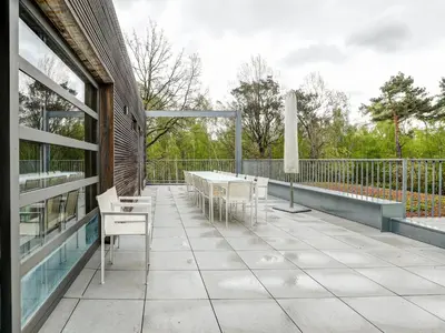a patio with tables and chairs on a building at Apartment in Weelde with swimming pool in Weelde