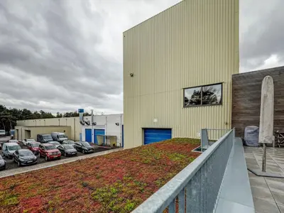 a yellow building with cars parked in a parking lot at Apartment in Weelde with swimming pool in Weelde
