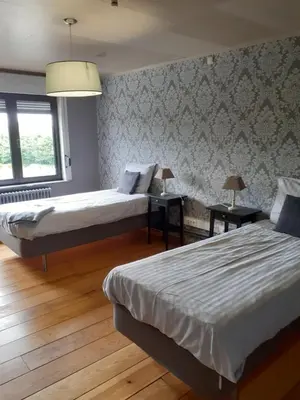 two beds in a room with two lamps on tables at Wenceslas Cobergher Penthouse in Boutersem