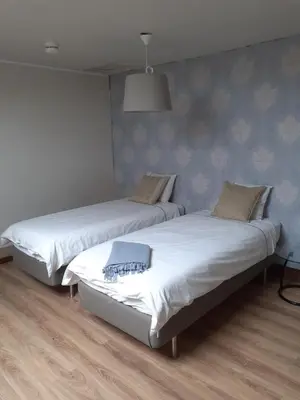 two twin beds in a room with wooden floors at Wenceslas Cobergher Penthouse in Boutersem