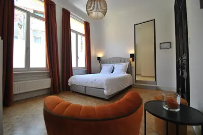 a bedroom with a bed and a chair and a table at Paulus41 in Antwerp