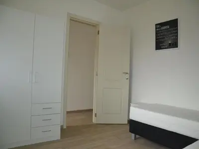 a bedroom with a bed and a closet and a door at Apartment in Antwerp near Verbeke Museum in Puivelde