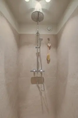 a shower in a bathroom with a shower head at Logie Marie with hottub in the garden in Lembeke