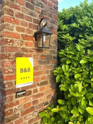 a sign on the side of a brick building at Logie Marie with hottub in the garden in Lembeke