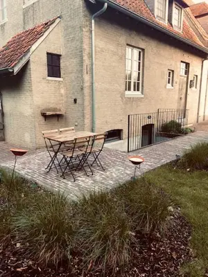 a picnic table in front of a building at Logie Marie with hottub in the garden in Lembeke