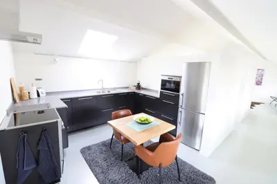 a small kitchen with a wooden table and chairs at Heritage Loft in Londerzeel