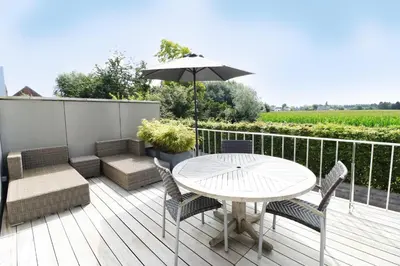 a patio with a table and chairs and an umbrella at Heritage Loft in Londerzeel