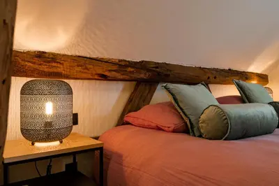 a bedroom with two beds and a lamp on a table at B&B Weselo in Mol