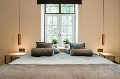 a bedroom with a large bed with two pillows at B&B Weselo in Mol