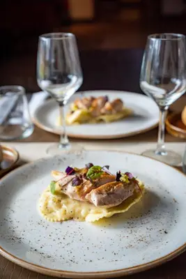 a plate of food on a table with two wine glasses at B&B Weselo in Mol