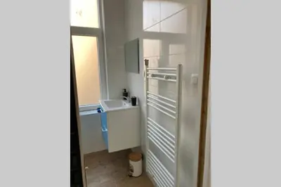 a small kitchen with white cabinets and a window at Magnifique Studio au 2ème étage, à proximité de la gare du midi! in Brussels
