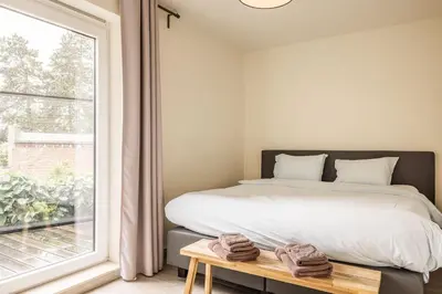 a bedroom with a bed and a large window at Red Rabbit Tourist and Business Flats with indoor parking - 1 to 5 or 6p - region gnt antwp brux in Zele