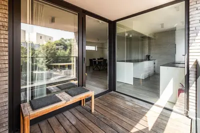 a screened in porch with a bench on a deck at Red Rabbit Tourist and Business Flats with indoor parking - 1 to 5 or 6p - region gnt antwp brux in Zele