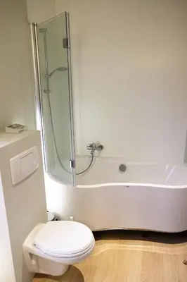 a bathroom with a shower and a toilet and a tub at Margareta Stay in Mechelen