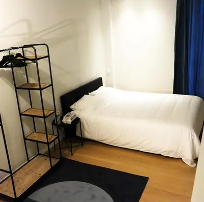 a bedroom with a white bed and a book shelf at Margareta Stay in Mechelen