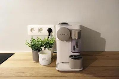 a white coffee machine sitting on a wooden counter at Margareta Stay in Mechelen
