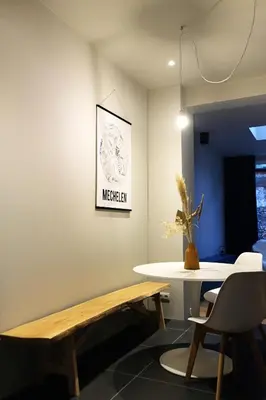 a living room with a table and a bench at Margareta Stay in Mechelen