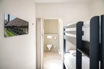 a bedroom with a bunk bed and a bathroom at Hotel Essenza in Puurs