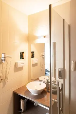a bathroom with a sink and a mirror at Hotel Essenza in Puurs