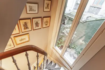 a stairway with a window and pictures on the wall at Luxury Suites Palace by Rikas Hotels in Antwerp