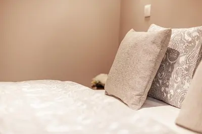 a bed with white sheets and pillows on it at Luxury Suites Palace by Rikas Hotels in Antwerp