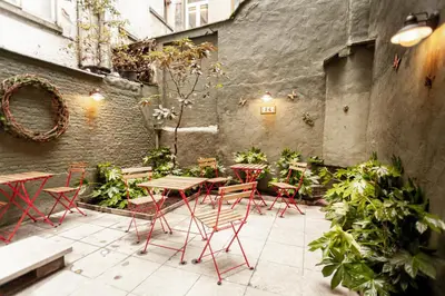 an outdoor patio with tables and chairs and plants at Luxury Suites Palace by Rikas Hotels in Antwerp