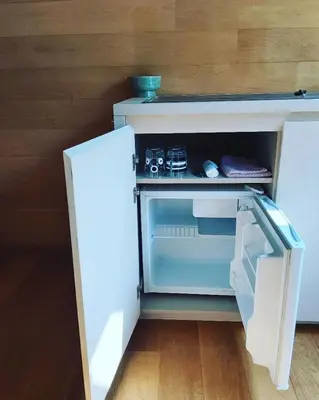 a small white refrigerator with its door open at De linderd in Aalst
