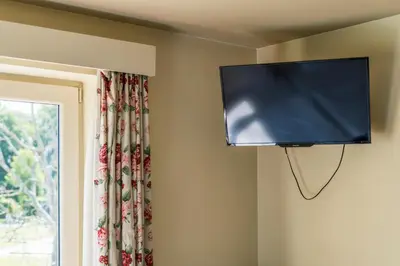 a flat screen tv hanging on a wall next to a window at Logie Bloemenlust in Wetteren