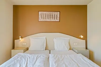 a bedroom with two beds with white sheets at Logie Bloemenlust in Wetteren