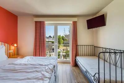 a bedroom with a bed and a television and a window at Logie Bloemenlust in Wetteren