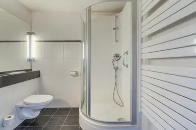 a bathroom with a toilet and a glass shower at Logie Bloemenlust in Wetteren