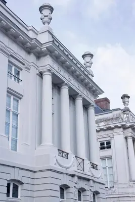 a white building with columns on top of it at Juliana Hotel & Spa - Brussels Centre in Brussels