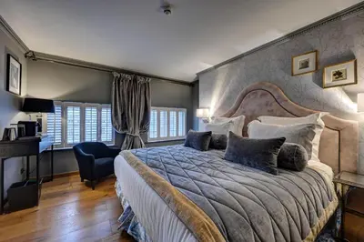 a bedroom with a large bed with blue pillows at Juliana Hotel & Spa - Brussels Centre in Brussels