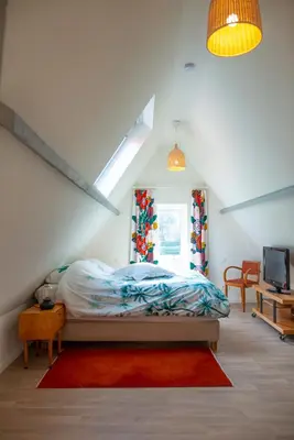 a bedroom with a bed and a television in it at DC's Home in Meise