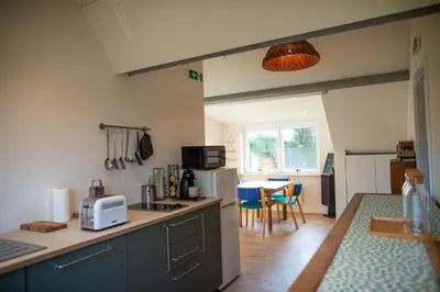 a kitchen with blue cabinets and a table with chairs at DC's Home in Meise