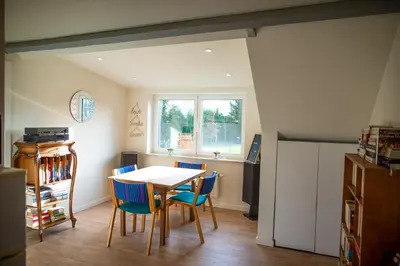 a dining room with a table and blue chairs at DC's Home in Meise