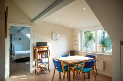 a dining room with a table and blue chairs at DC's Home in Meise