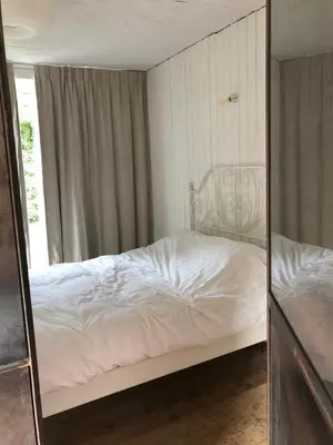 a mirror reflection of a bed in a bedroom at Vakantiehuis De Sneppelhoeve in Loenhout