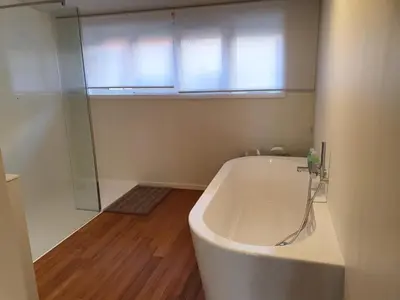 a bathroom with a bath tub and a window at Vakantiehuis De Sneppelhoeve in Loenhout