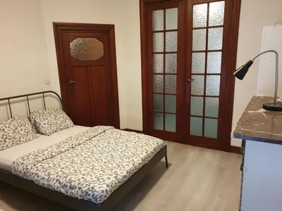 a bedroom with a bed and a table with a lamp at Near European District, 1-2 Bedroom Apartment. in Brussels