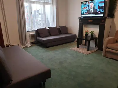 a living room with a couch and a television at Near European District, 1-2 Bedroom Apartment. in Brussels