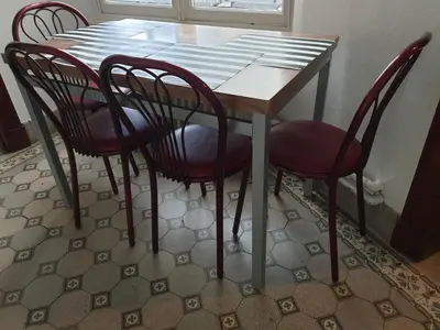 a dining room table with four red chairs around it at Near European District, 1-2 Bedroom Apartment. in Brussels