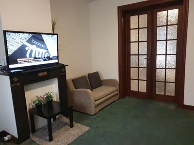 a living room with a couch and a tv on a fireplace at Near European District, 1-2 Bedroom Apartment. in Brussels