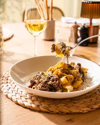 a bowl of pasta with a glass of wine at Van der Valk Hotel Gent in Ghent